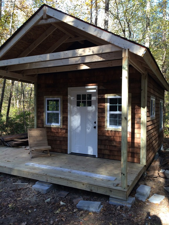 Tiny cabin in the woods with roofing and partial siding installed