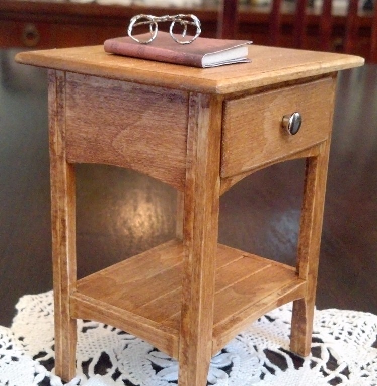 Finished miniature night stand with small book and glasses