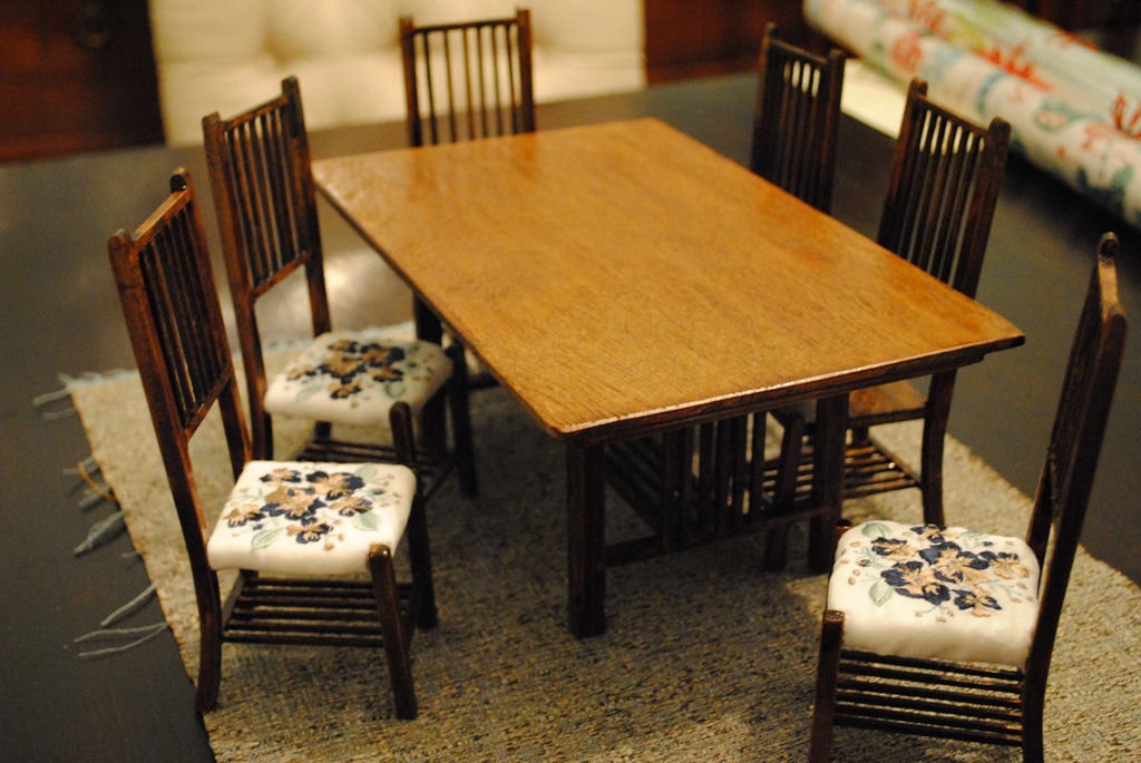 Model table and chairs with embroidered seat cushions