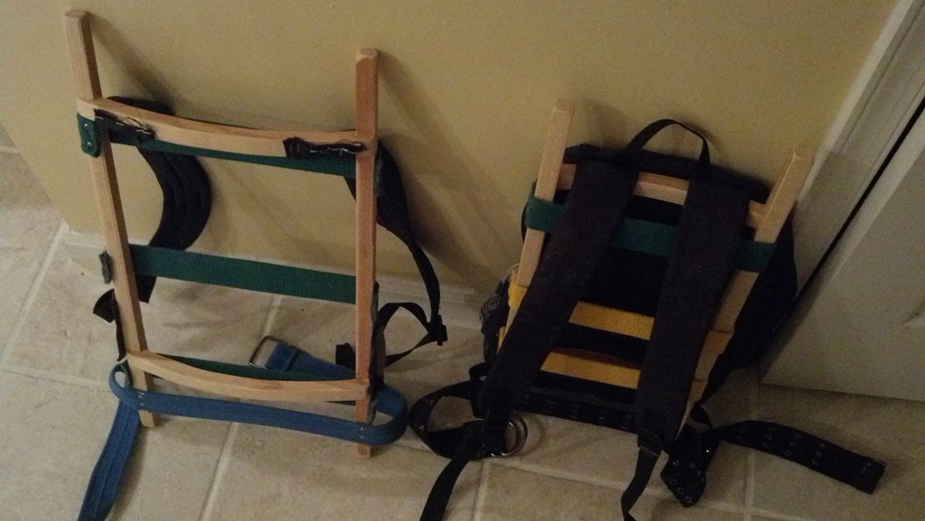 Salvaged straps and pack parts attached to a DIY wooden backpack frame